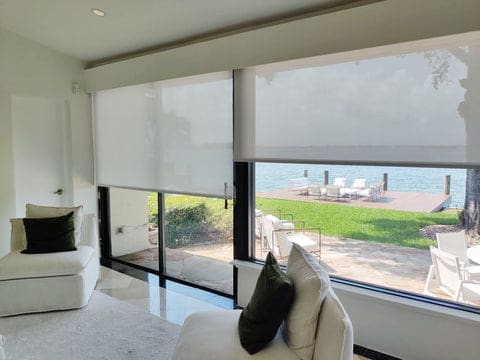 Solar roller shades on a sliding glass door with black frame